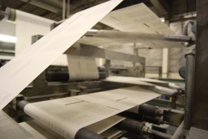 Printed web paper running through crossover rollers