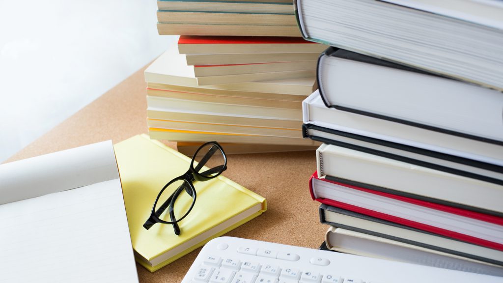 Publisher's desk with piles of books